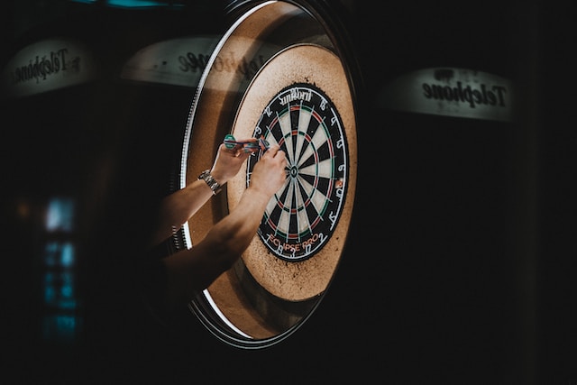 player picking darts out of board